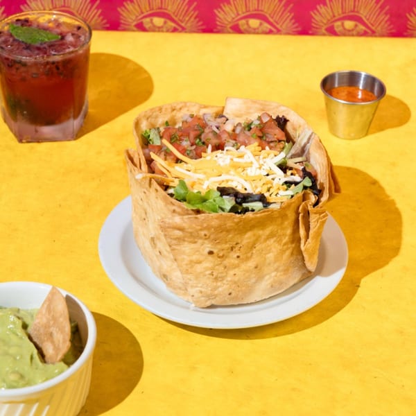 Friducha's taco salad in a crispy shell, with guacamole, salsa, and a berry drink.